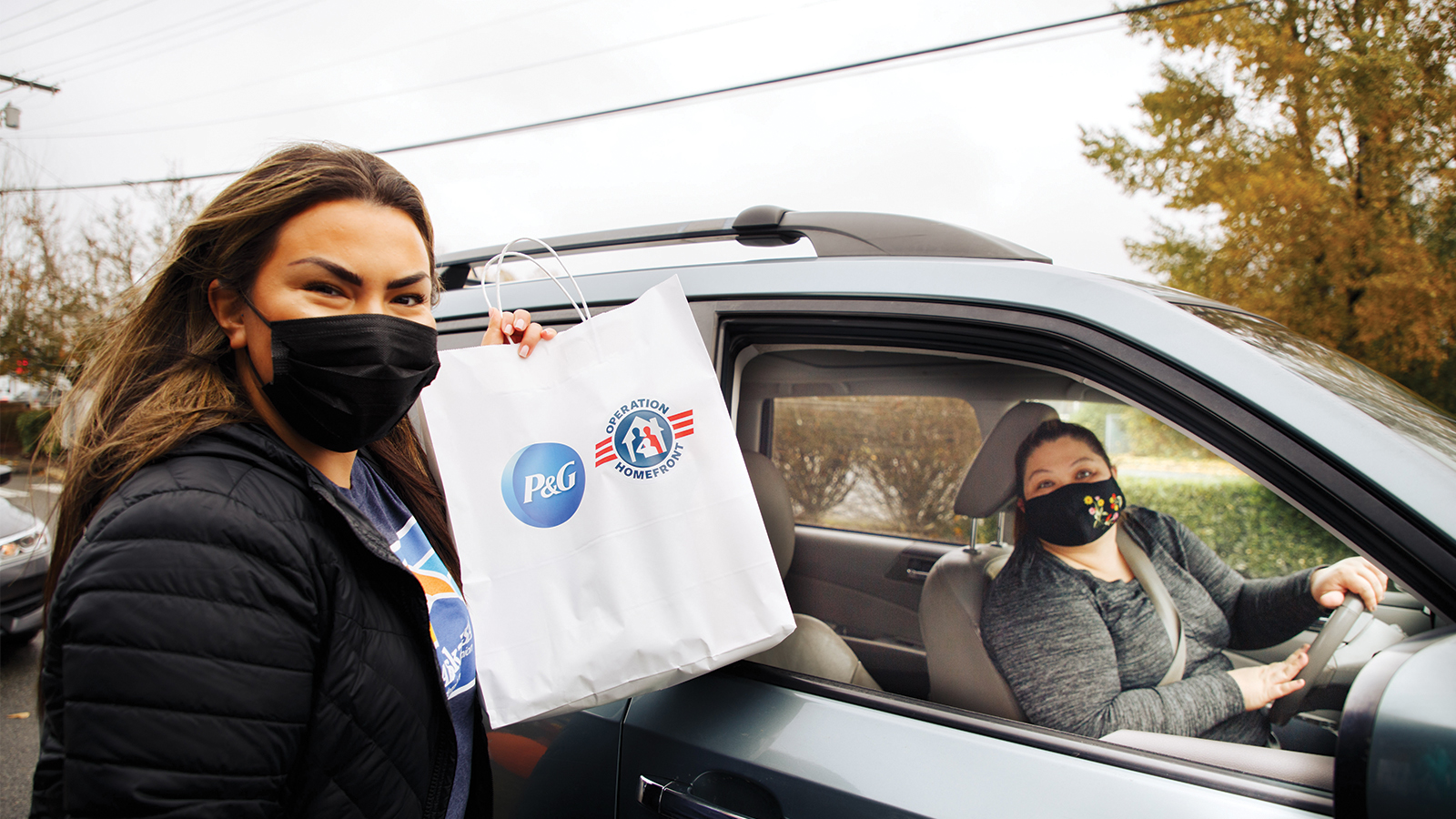 Volunteer and receiver pictured with a holiday gift bag.